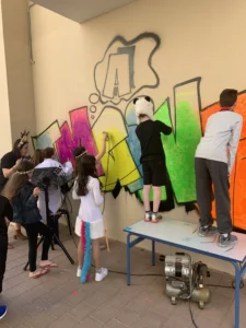 ילדים עושים ציור גרפיטי על קיר