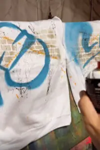 גרפיטי מקצועי על סווטשרטים לבנים עם סלוגן החברה