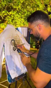 "מג'יק בן מעצב סווטשרטים במפגש משפחתי - שילוב שמות המשפחה בגרפיטי צבעוני על רקע כהה"